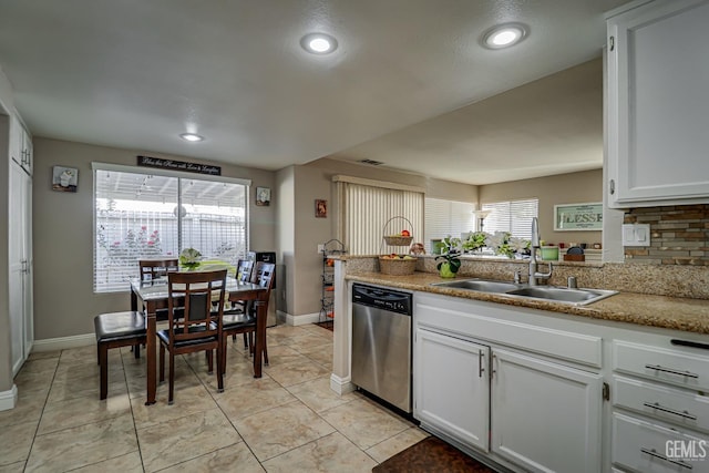 kitchen featuring backsplash, white cabinets, sink, stainless steel dishwasher, and light stone countertops