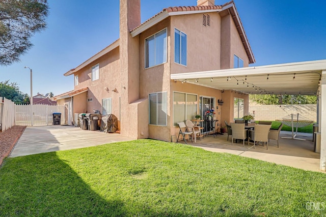 rear view of property with a yard and a patio