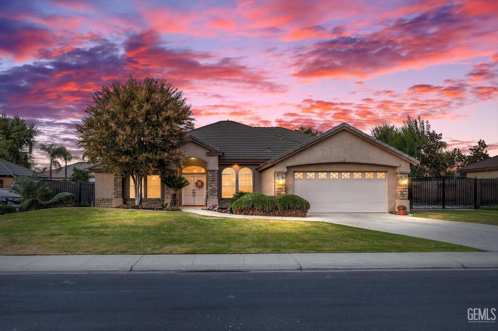 view of front of home featuring a garage and a lawn