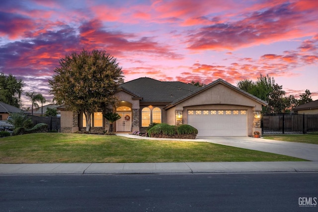 view of front of home featuring a garage and a lawn