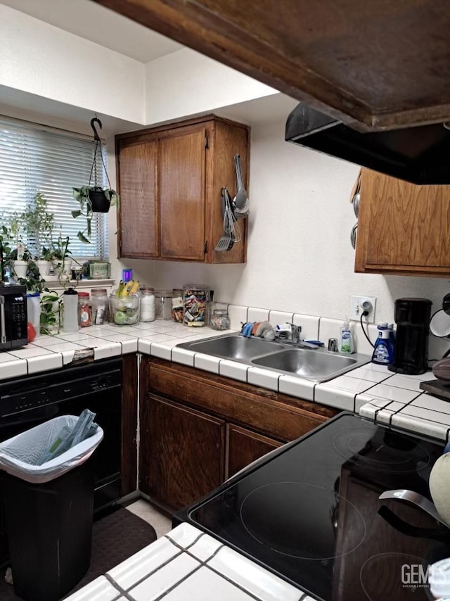 kitchen featuring tile countertops, dishwasher, range, and sink