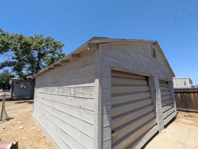 view of outbuilding with fence and an outdoor structure