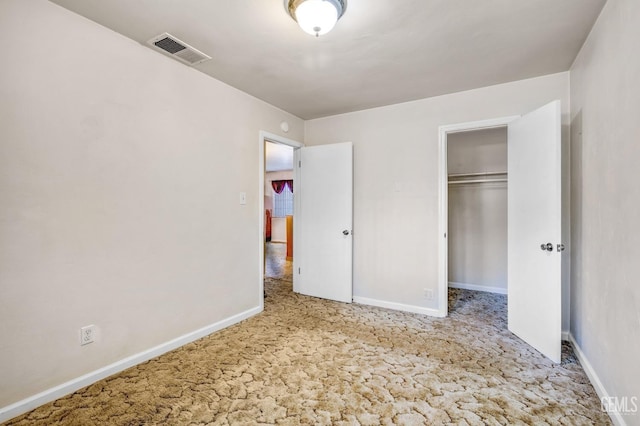 unfurnished bedroom with light colored carpet and a closet