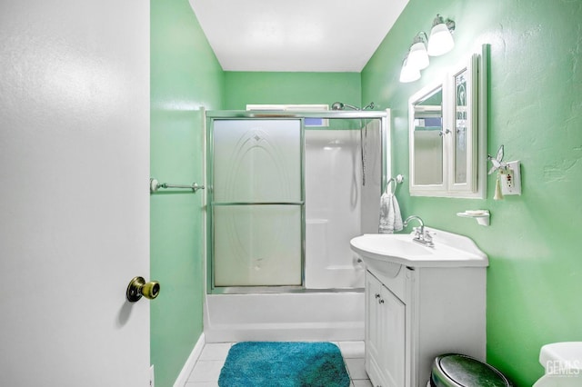 full bathroom with tile patterned floors, vanity, bath / shower combo with glass door, and toilet