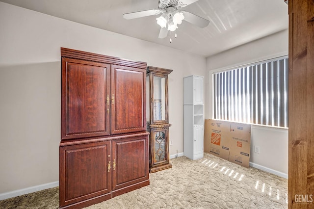 interior space with carpet flooring and ceiling fan