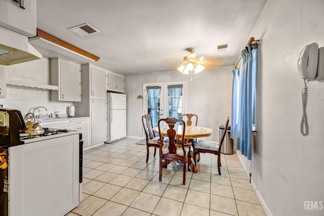 kitchen with white cabinets, light tile patterned floors, white appliances, and french doors