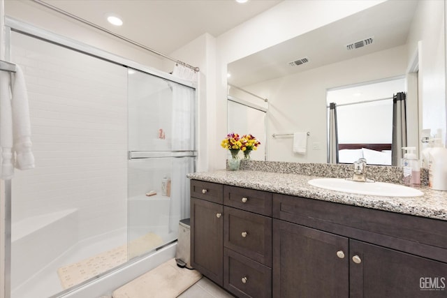 bathroom featuring tile patterned flooring, vanity, and an enclosed shower