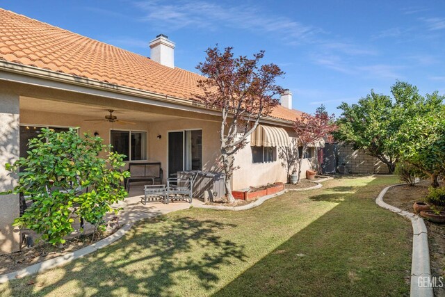 3010 Tea Rose St, Bakersfield, CA 93311 - view of grassy yard featuring ceiling fan and a patio area