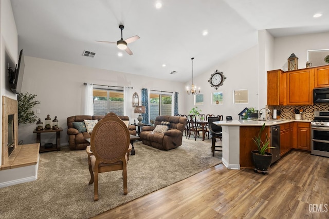3010 Tea Rose St, Bakersfield, CA 93311 - living area with wood finished floors, a chandelier, ceiling fan, a tiled fireplace, and high vaulted ceiling