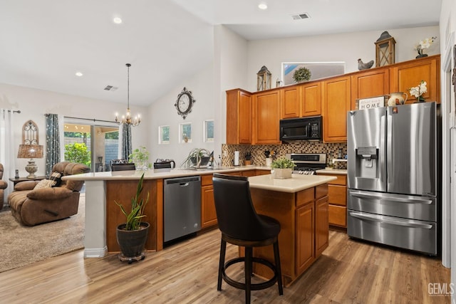 3010 Tea Rose St, Bakersfield, CA 93311 - kitchen with appliances with stainless steel finishes, open floor plan, a peninsula, light countertops, and brown cabinets