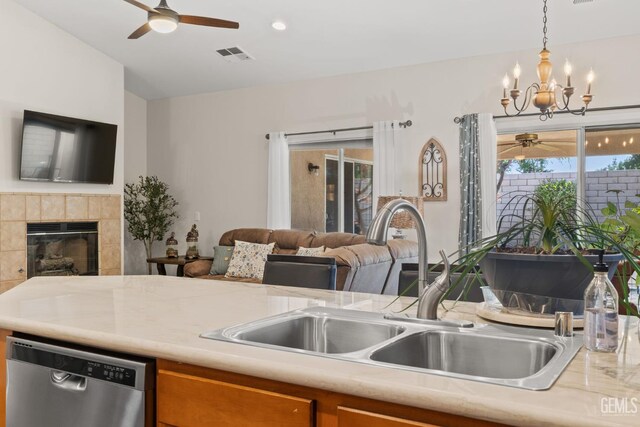 3010 Tea Rose St, Bakersfield, CA 93311 - kitchen featuring stainless steel dishwasher, ceiling fan, open floor plan, light countertops, and a tile fireplace