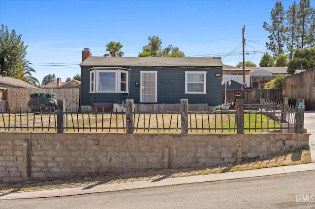 view of front of home featuring a fenced front yard and a chimney