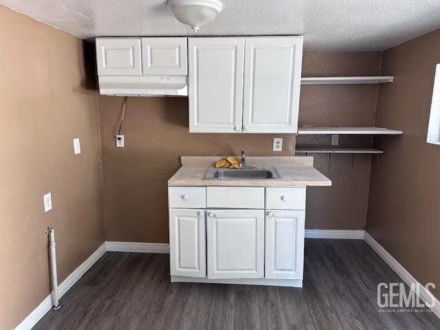 780 Mayer Ln, Bakersfield, CA 93263 - kitchen featuring a sink, dark wood-style flooring, white cabinetry, and a textured ceiling