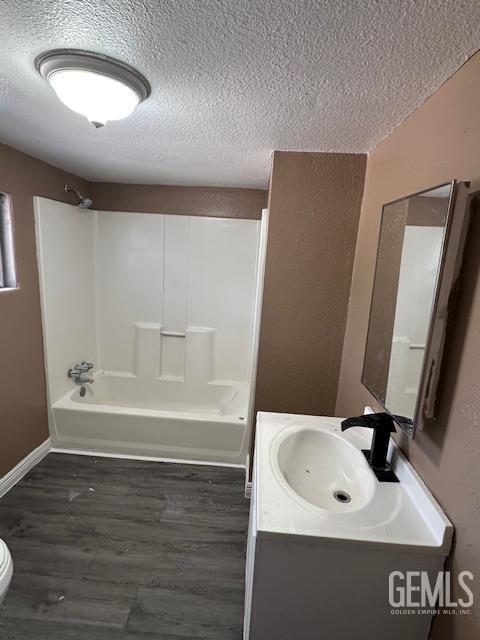 780 Mayer Ln, Bakersfield, CA 93263 - full bath featuring a textured ceiling, vanity, shower / washtub combination, wood finished floors, and toilet