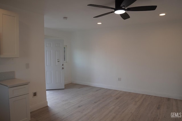 unfurnished room with ceiling fan and light wood-type flooring