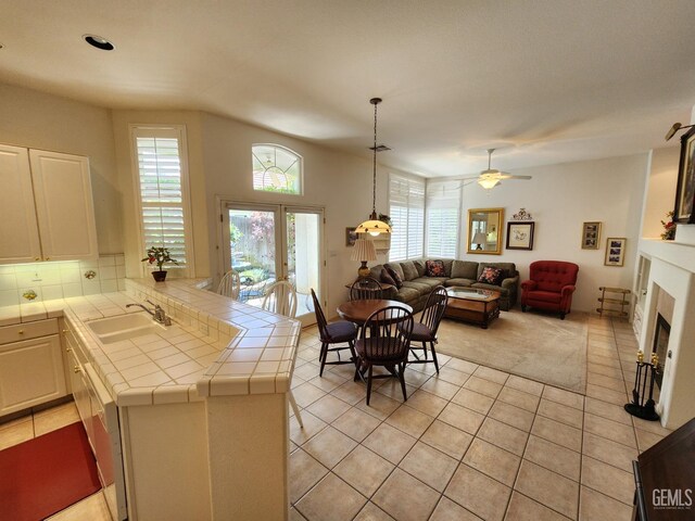 8707 Beau Maison Way, Bakersfield, CA 93311 - kitchen featuring tile counters, a sink, light tile patterned flooring, a fireplace, and ceiling fan