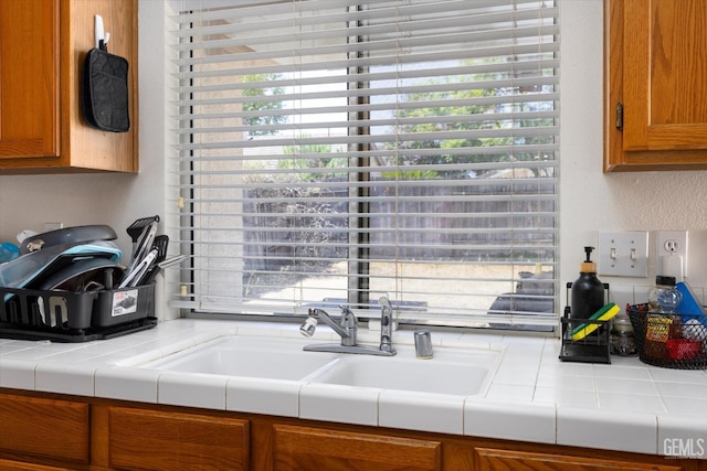 7507 Hidden Bridge Dr, Bakersfield, CA 93313 - detailed view of tile counters, brown cabinetry, and a textured wall