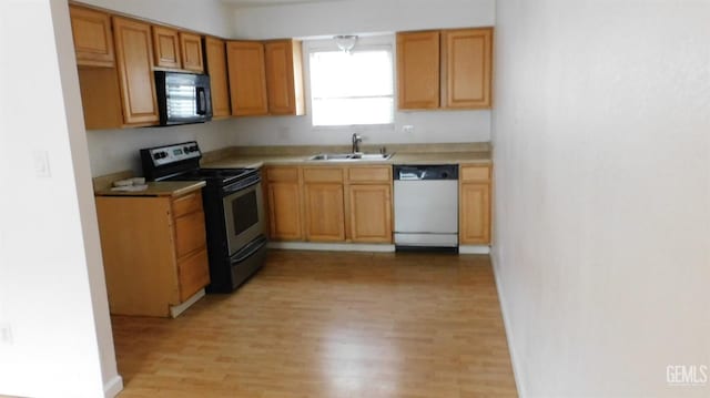 kitchen featuring light wood-type flooring, sink, and black appliances