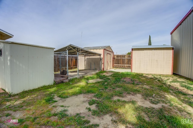 view of yard with an outbuilding, fence, and a storage shed