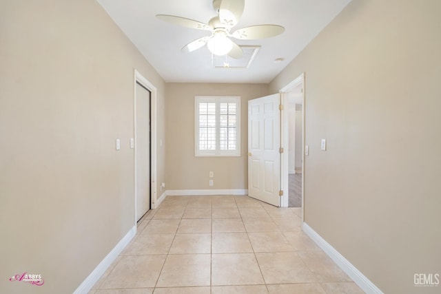 interior space with light tile patterned floors, ceiling fan, and baseboards