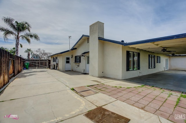 view of home's exterior featuring a patio, fence, a ceiling fan, and stucco siding