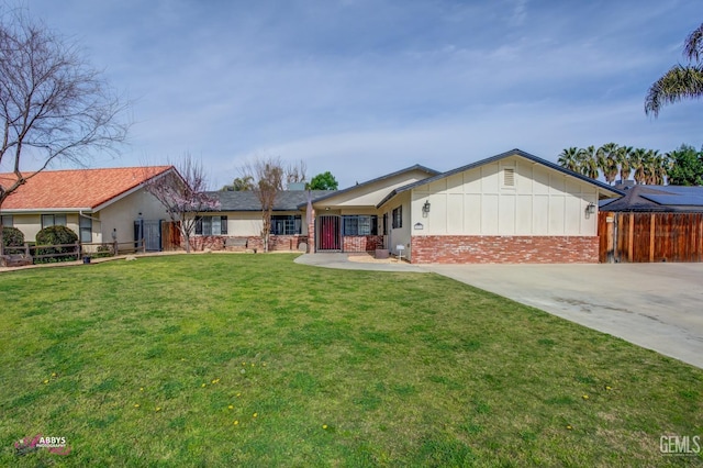 single story home featuring fence, a front lawn, concrete driveway, and brick siding