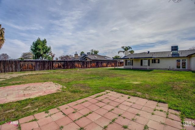 view of yard with a fenced backyard, french doors, and a patio