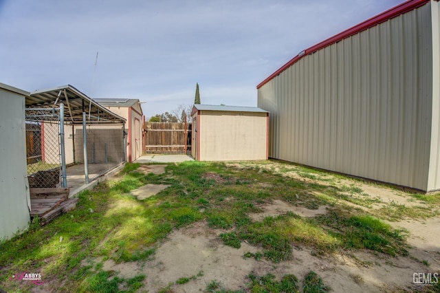 view of yard featuring fence and an outbuilding