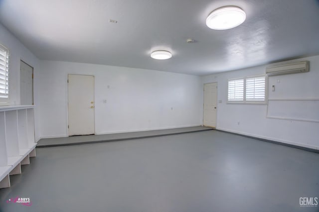 interior space featuring baseboards and a wall mounted AC