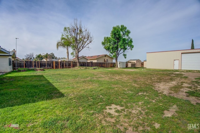 view of yard with fence and an outbuilding