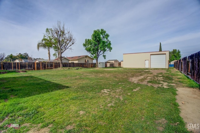 view of yard featuring a garage, fence, and an outdoor structure