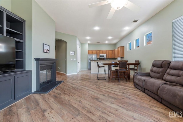 living room with ceiling fan and light wood-type flooring