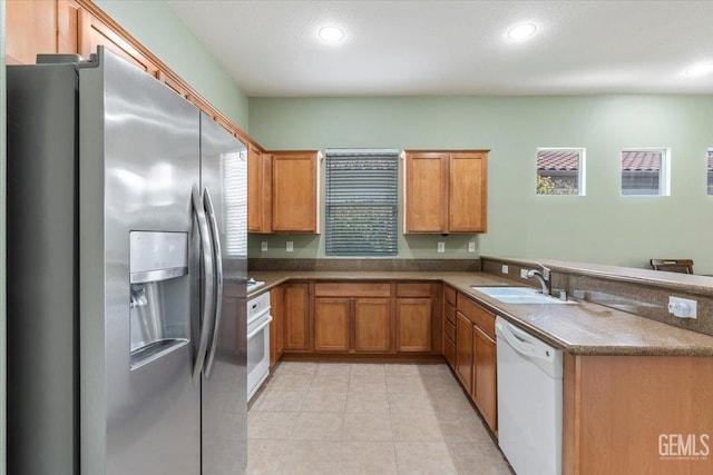 kitchen featuring sink, white appliances, and kitchen peninsula