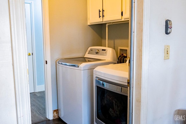 washroom with washer and dryer and cabinets