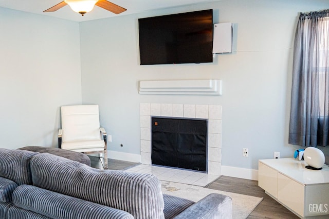 living room with a tile fireplace and hardwood / wood-style flooring