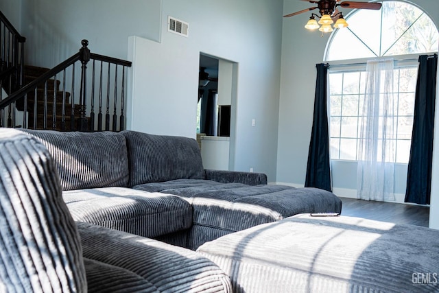 bedroom with ceiling fan, wood-type flooring, and a high ceiling