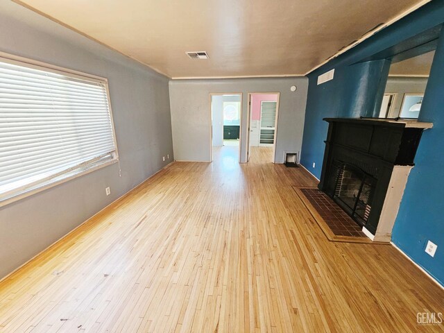 2313 Alturas Dr, Bakersfield, CA 93305 - unfurnished living room with wood-type flooring, plenty of natural light, and a fireplace with flush hearth