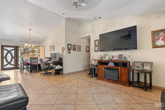 tiled living room with ceiling fan with notable chandelier and vaulted ceiling