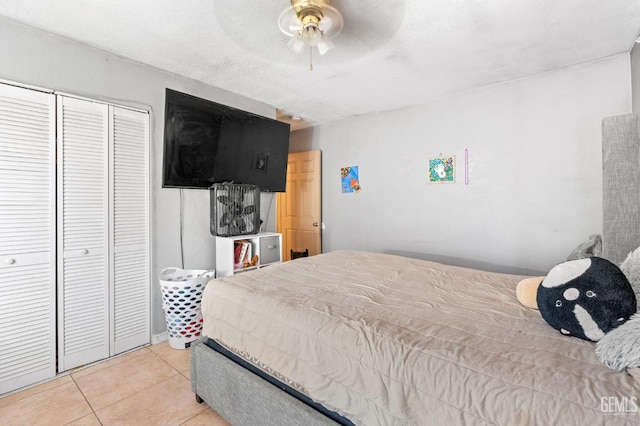 bedroom with a closet, ceiling fan, and light tile patterned flooring