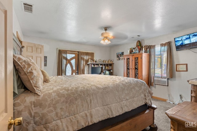 bedroom with carpet, a textured ceiling, ceiling fan, and cooling unit