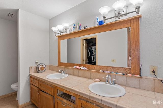 bathroom featuring tile patterned flooring, vanity, and toilet