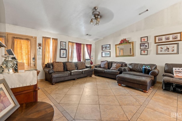 living room featuring ceiling fan, light tile patterned floors, and vaulted ceiling