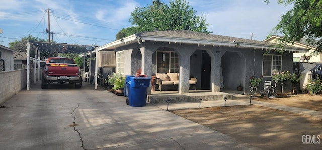 ranch-style house featuring driveway, outdoor lounge area, and stucco siding