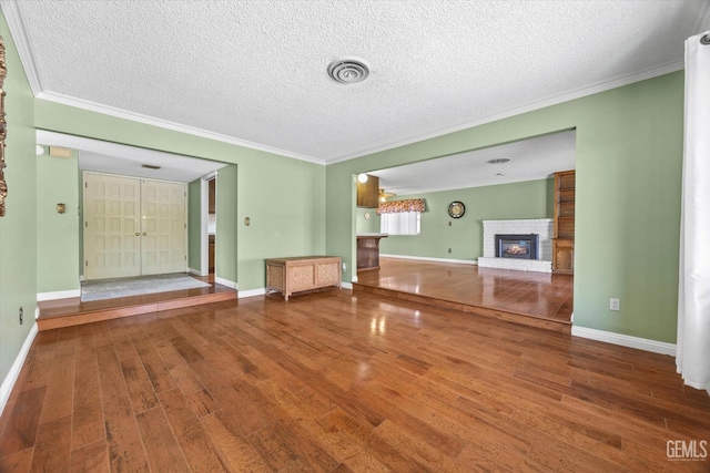 unfurnished living room with a textured ceiling, a fireplace, and hardwood / wood-style floors