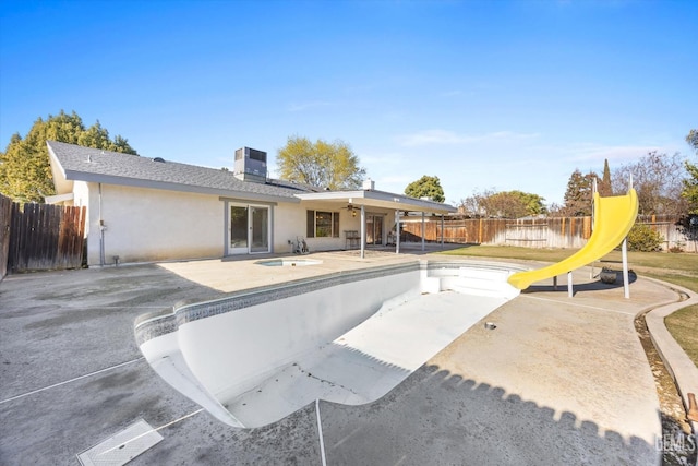 back of house with an empty pool, ceiling fan, a patio area, and central air condition unit