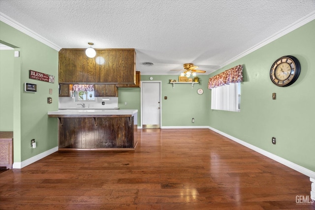 kitchen with kitchen peninsula, a textured ceiling, ceiling fan, and ornamental molding