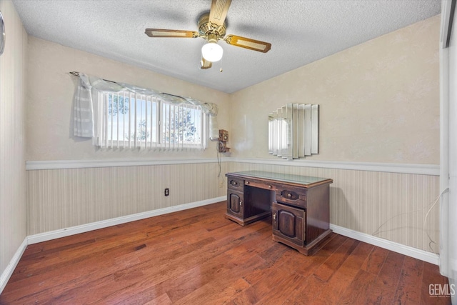 home office featuring hardwood / wood-style flooring, ceiling fan, and a textured ceiling