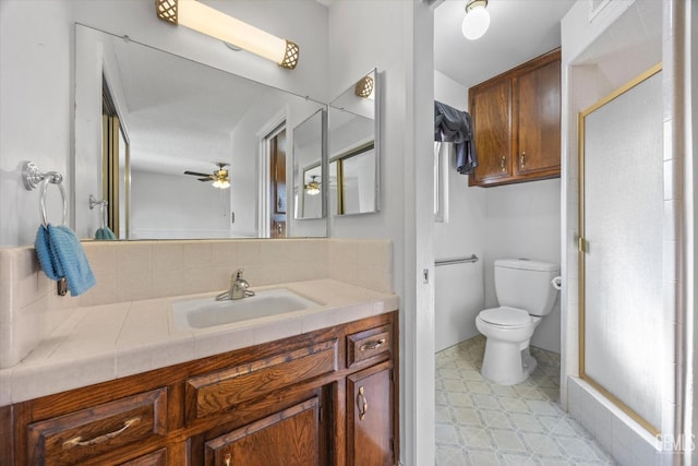 bathroom with ceiling fan, toilet, a shower with shower door, and vanity