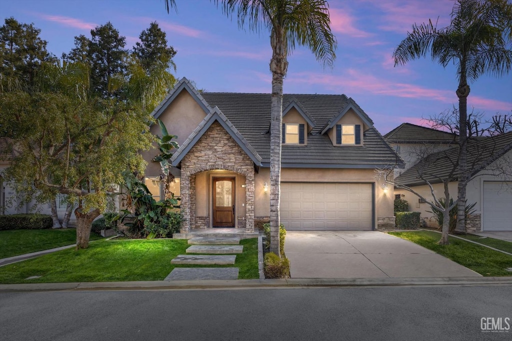 view of front of property with a yard and a garage