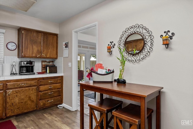 808 La Puente Dr, Bakersfield, CA 93309 - kitchen featuring tasteful backsplash, wood finished floors, tile counters, and brown cabinets